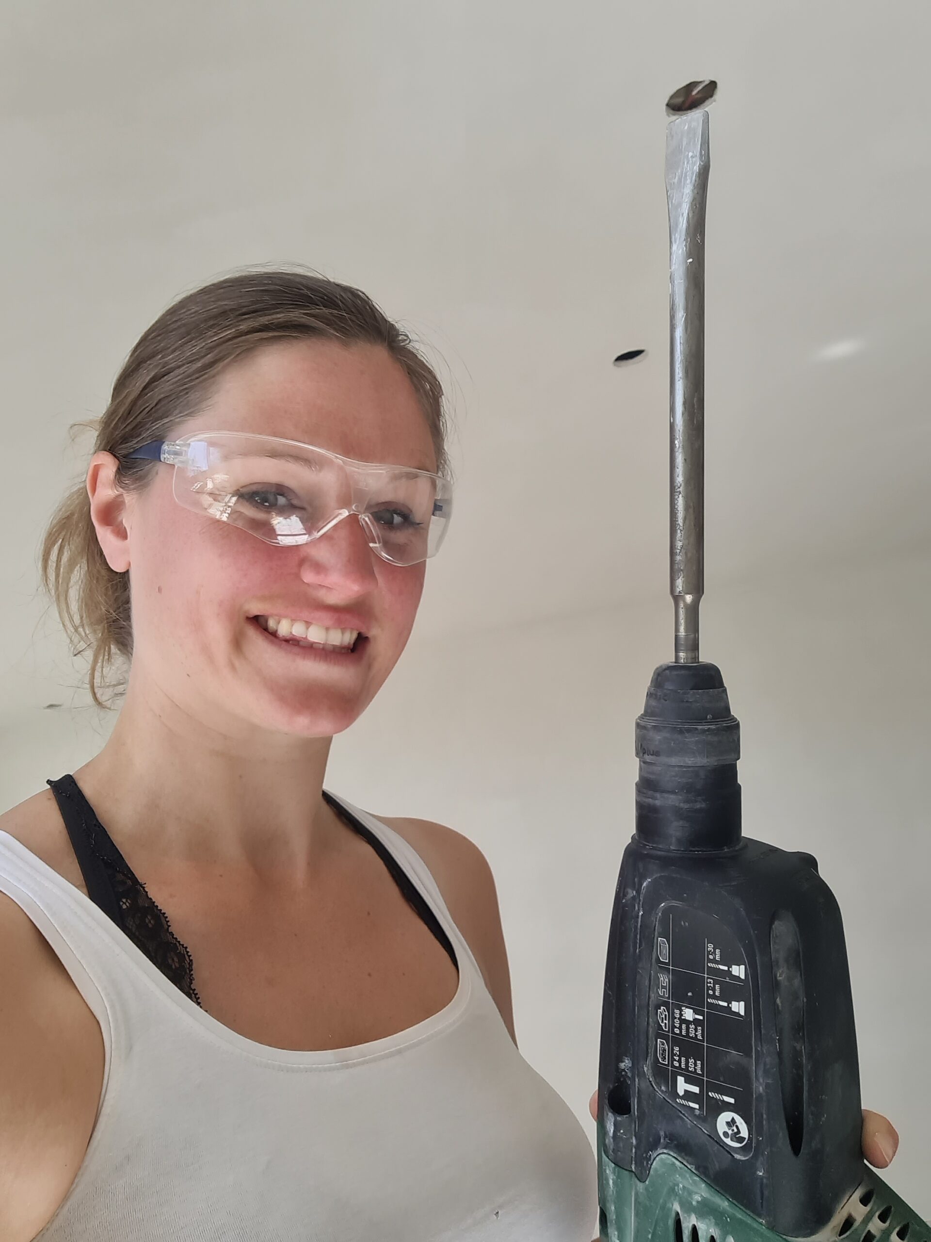 Jess aan het werk met een boorhamer en veiligheidsbril